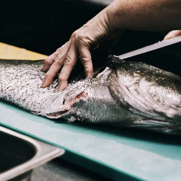 Un pesce intero su un tagliere, pulito a mano