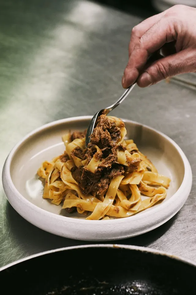 Il ragù adagiato sulle tagliatelle appena impiattate